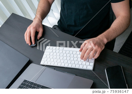 デスクに向かってキーボードをタイピングする男性の手 デスクに向かってキーボードをタイピングする男性の手 75936147