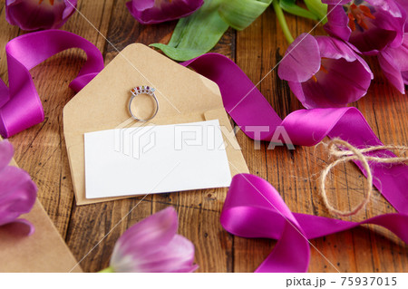 Purple tulips and blank card on wooden table Purple tulips and blank card on wooden table 75937015