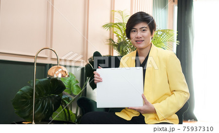Working Asian smart woman in yellow suit holding white copy space banner in luxury interior background Working Asian smart woman in yellow suit holding white copy space banner in luxury interior background 75937310