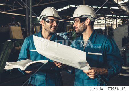 Group of skillful factory workers using machine equipment in workshop 75938112