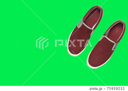 Casual brown sneakers on green background. Casual brown sneakers on green background. 75939232