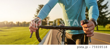 Website header of Getting ready to ride. Cropped shot of a road bicycle racer in sportswear standing on the road in park at sunset, cycling outdoors Website header of Getting ready to ride. Cropped shot of a road bicycle racer in sportswear standing on the road in park at sunset, cycling outdoors 75939518
