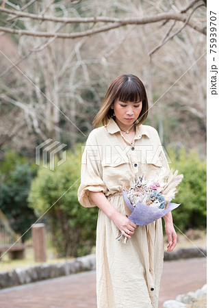 花を愛でる、花を持つ女性 75939707