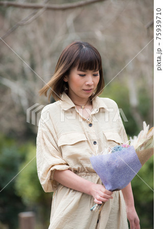 花を愛でる 花を持つ女性の写真素材