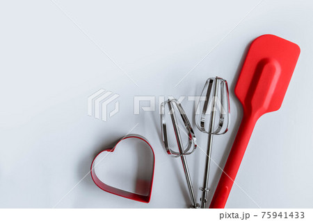 Baking supplies on white. Spatula, mixer whisks, cookie cutter on white background Baking supplies on white. Spatula, mixer whisks, cookie cutter on white background 75941433