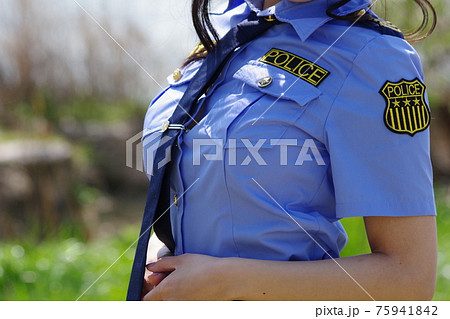 日差しの中の女性警察官の胸 ネクタイの写真素材