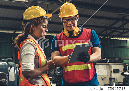 Two skillful factory engineer or worker discussing project on tablet computer Two skillful factory engineer or worker discussing project on tablet computer 75945713