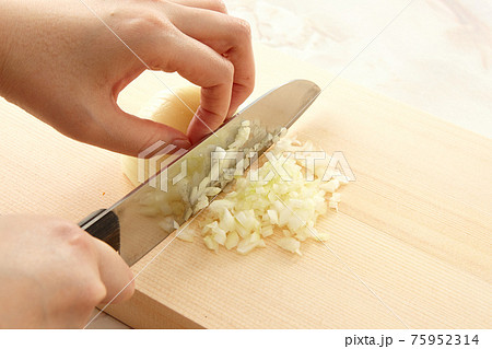 玉ねぎをみじん切りにしている手元 玉ねぎをみじん切りにしている手元 75952314