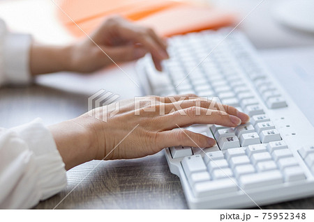 パソコンのキーボードを操作する女性の手 75952348