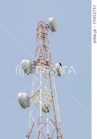 Telecommunication tower on clean blue sky background. Tower poles and wireless telephone antennas. Telecommunication tower on clean blue sky background. Tower poles and wireless telephone antennas. 75952757