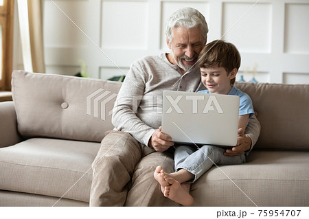Happy mature grandfather and little grandson use laptop 75954707