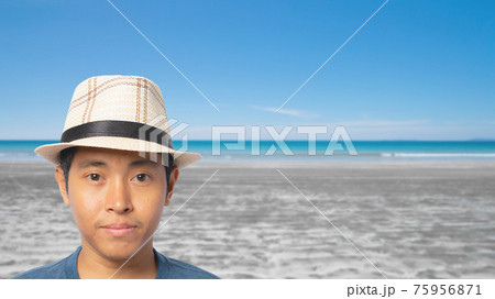 Portrait of young man wearing straw hat on the beach. Portrait of young man wearing straw hat on the beach. 75956871