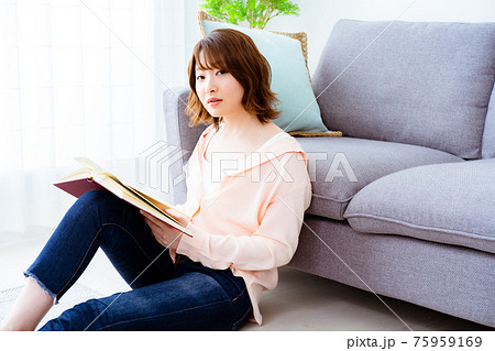 休日に読書をする一人暮らしの若い女性の写真素材