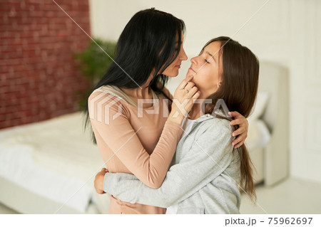 Mother and daughter time. Loving latin mother playing with her teenage daughter, looking affectionate while posing together at home 75962697