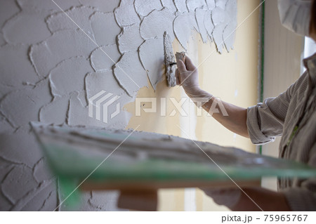 新築一戸建て住宅の工事現場で珪藻土を縫っているところ 75965767