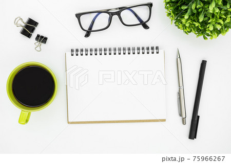 White office desk table with blank notebook page and supplies. Top view, flat lay. 75966267
