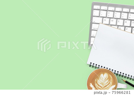 Green pastel office desk table with coffee, computer keyboard, notebook and pencil. Top view with copy space, flat lay. 75966281