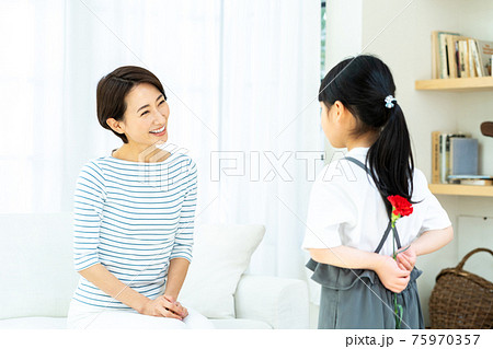 母の日にカーネーションを渡す女の子。 母の日にカーネーションを渡す女の子。 75970357