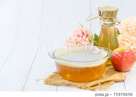 Scoby and Kombucha tea in bowl glass on wood background, cider fermented drink. 75970656