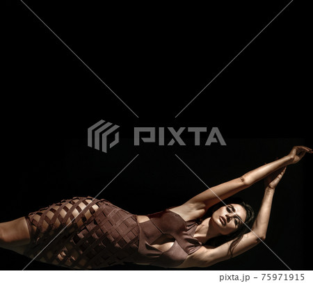 Portrait of a young, brunette, classy woman posing in shade 75971915