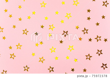 Confetti golden stars on pink background. Holiday backdrop. Colorful celebration, birthday. Christmas or New Year pattern. Flat lay, top view Confetti golden stars on pink background. Holiday backdrop. Colorful celebration, birthday. Christmas or New Year pattern. Flat lay, top view 75972378
