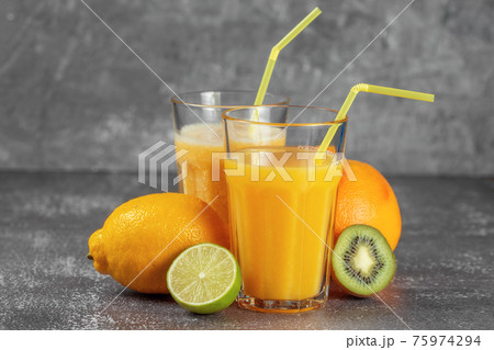 Freshly squeezed orange juice and banana and orange smoothies in tall glasses 75974294