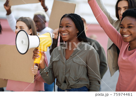 Cheerful black lady leading international group of protestors Cheerful black lady leading international group of protestors 75974461