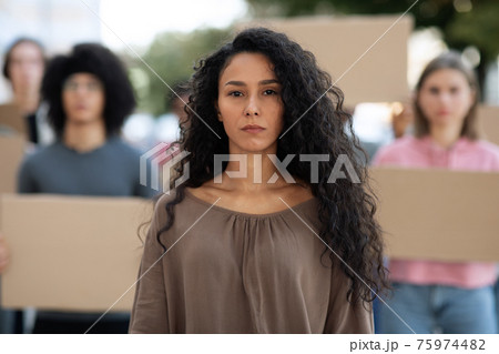 Confident young woman over group of activists 75974482