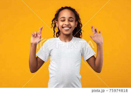 Hopeful african american girl crossing her fingers 75974818