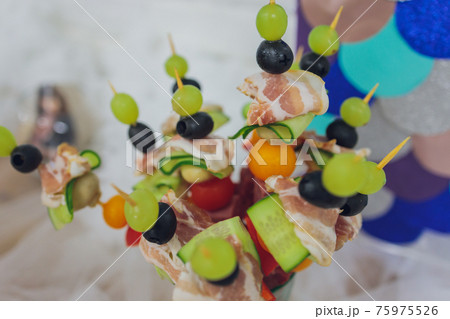 Beautifully decorated catering banquet table with different food snacks and appetizers with sandwich, caviar, fresh fruits on corporate christmas birthday party event or wedding celebration. 75975526