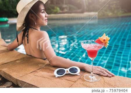 Young back woman in bikini swimming pool drink cocktail 75979404
