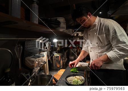 厨房で調理をするシェフ 75979563