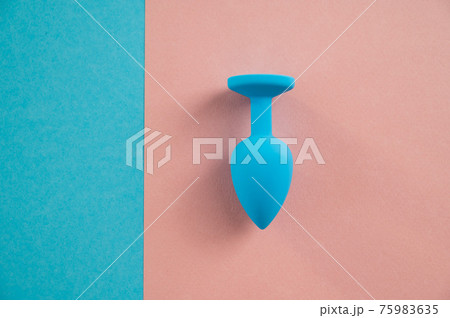 Blue anal plug on a pink background. Plastic sex toy for alternative sex. Copy space. 75983635
