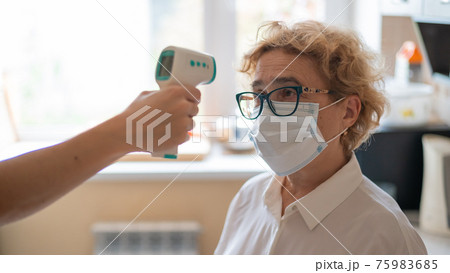 The doctor measures the temperature of an elderly woman with an electronic thermometer The doctor measures the temperature of an elderly woman with an electronic thermometer 75983685
