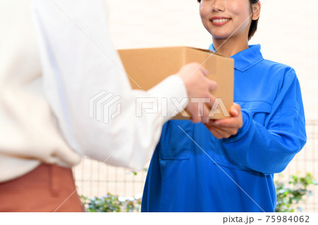 荷物を届ける作業服をきた女性ドライバー（宅配便） 75984062