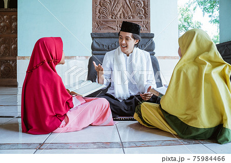 Portrait asian Muslim male teachers teach two girls to read the Quran Portrait asian Muslim male teachers teach two girls to read the Quran 75984466
