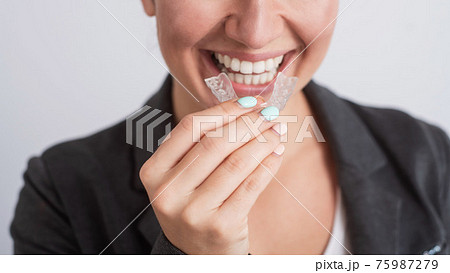 Business woman uses transparent braces to whiten teeth Business woman uses transparent braces to whiten teeth 75987279