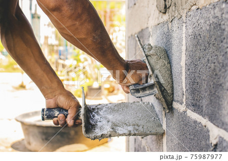 Close-up of workers using plaster trowel to plaster the walls for house construction, working ideas and residential construction. 75987977