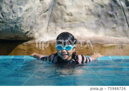 Cute girl with goggles having fun in summer in the pool summer vacation concept Cute girl with goggles having fun in summer in the pool summer vacation concept 75988726