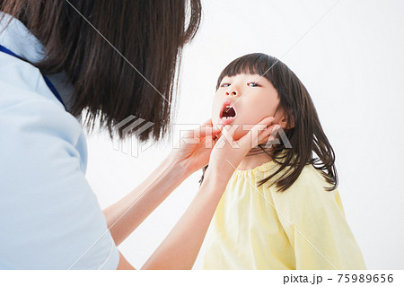 歯医者さんに治療をしてもらう小さな女の子 歯医者さんに治療をしてもらう小さな女の子 75989656