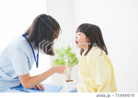 歯医者さんに治療をしてもらう小さな女の子 75989670