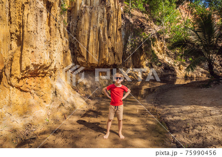 Boy tourist on the Fairy stream among the red dunes, Muine, Vietnam. Vietnam opens borders after quarantine COVID 19 75990456
