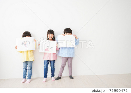 自分で描いた絵を見せる小さな子どもたち 自分で描いた絵を見せる小さな子どもたち 75990472