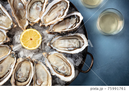 Oysters with wine, shot from above on a blue background Oysters with wine, shot from above on a blue background 75991761