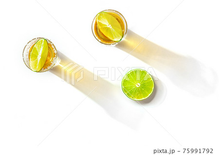 Tequila shots with salty rims and lime slices, overhead flat lay shot 75991792