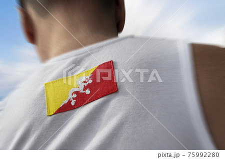 The national flag of Bhutan on the athlete's back The national flag of Bhutan on the athlete's back 75992280