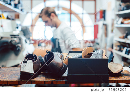 Shoemaker or cobbler in his traditional workshop 75993205