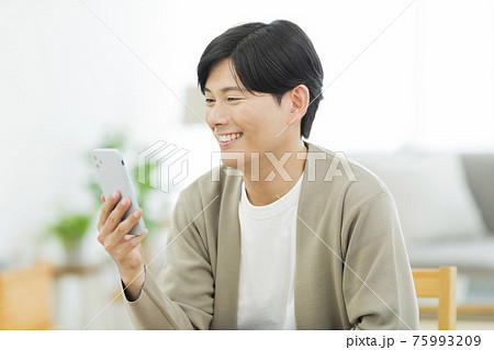 スマホを見る男性 75993209