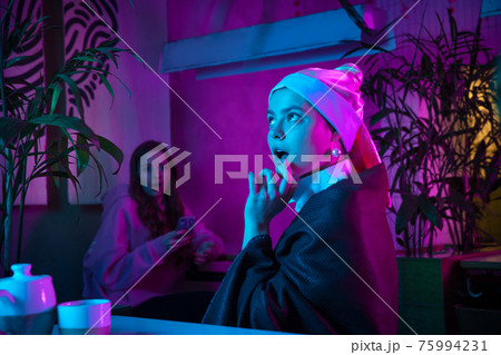 Beautiful girl with a pearl earring taking lunch in modern cafe, restaurant in neon light Beautiful girl with a pearl earring taking lunch in modern cafe, restaurant in neon light 75994231