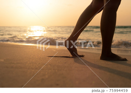 Woman feet walk slow life and relax on sand tropical beach with blue sky. Woman feet walk slow life and relax on sand tropical beach with blue sky. 75994459